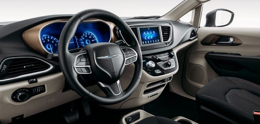 An interior view of the steering wheel, dashboard and touchscreen of the 2020 Chrysler Voyager.